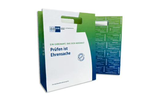 Papiertasche mit ausgestanztem Griff, bunt bedruckt mit einem Motiv der IHK Dresden zur Prüfgerneuberufung Farbtöne türkis, blau und grün, Größe A4