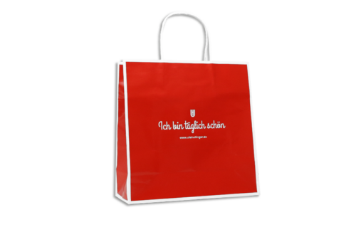 Glänzende Papiertasche rot-weiß mit Papierkordeln und weißem Aufdruck "Ich bin täglich schön" für Ute Hollinger
